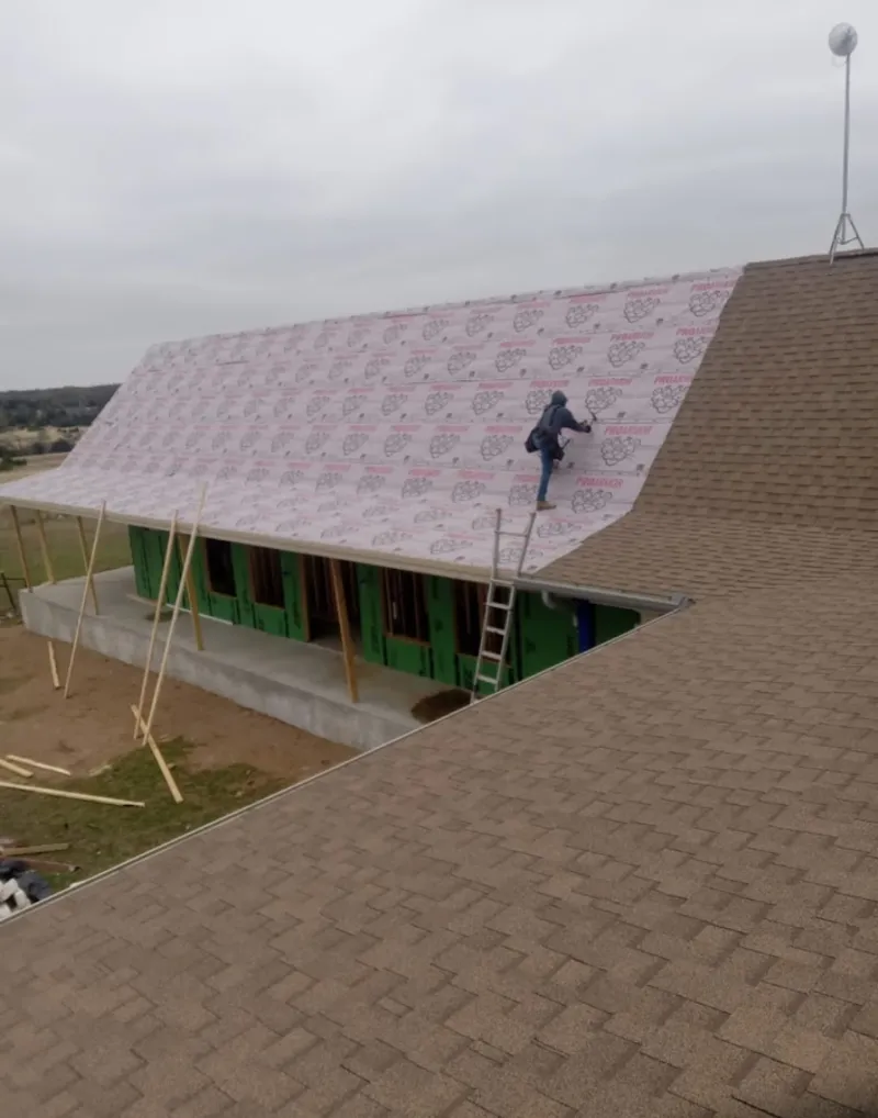 Worker preparing underlayment for a metal roof installation in Richmond
